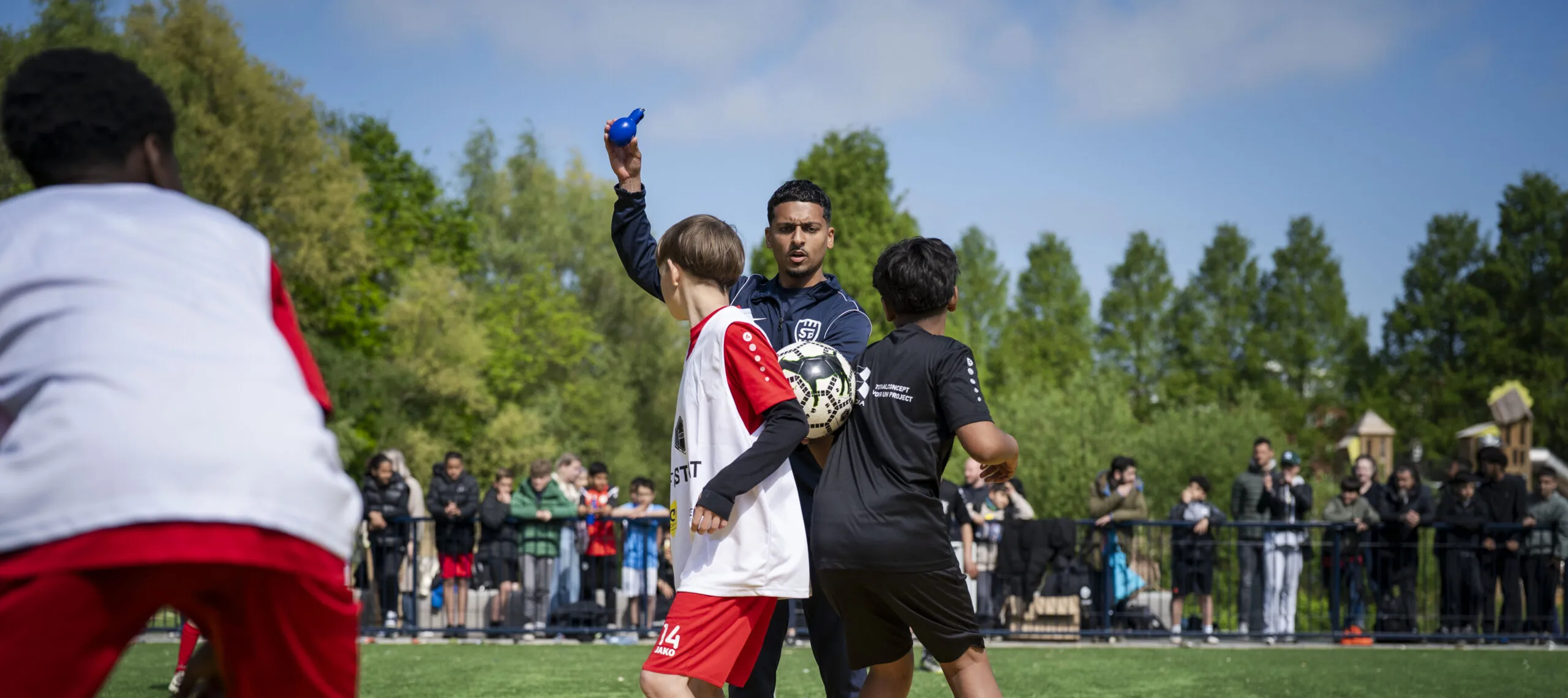 Een buurtsportcoach als scheidsrechter tijdens een potje voetbal