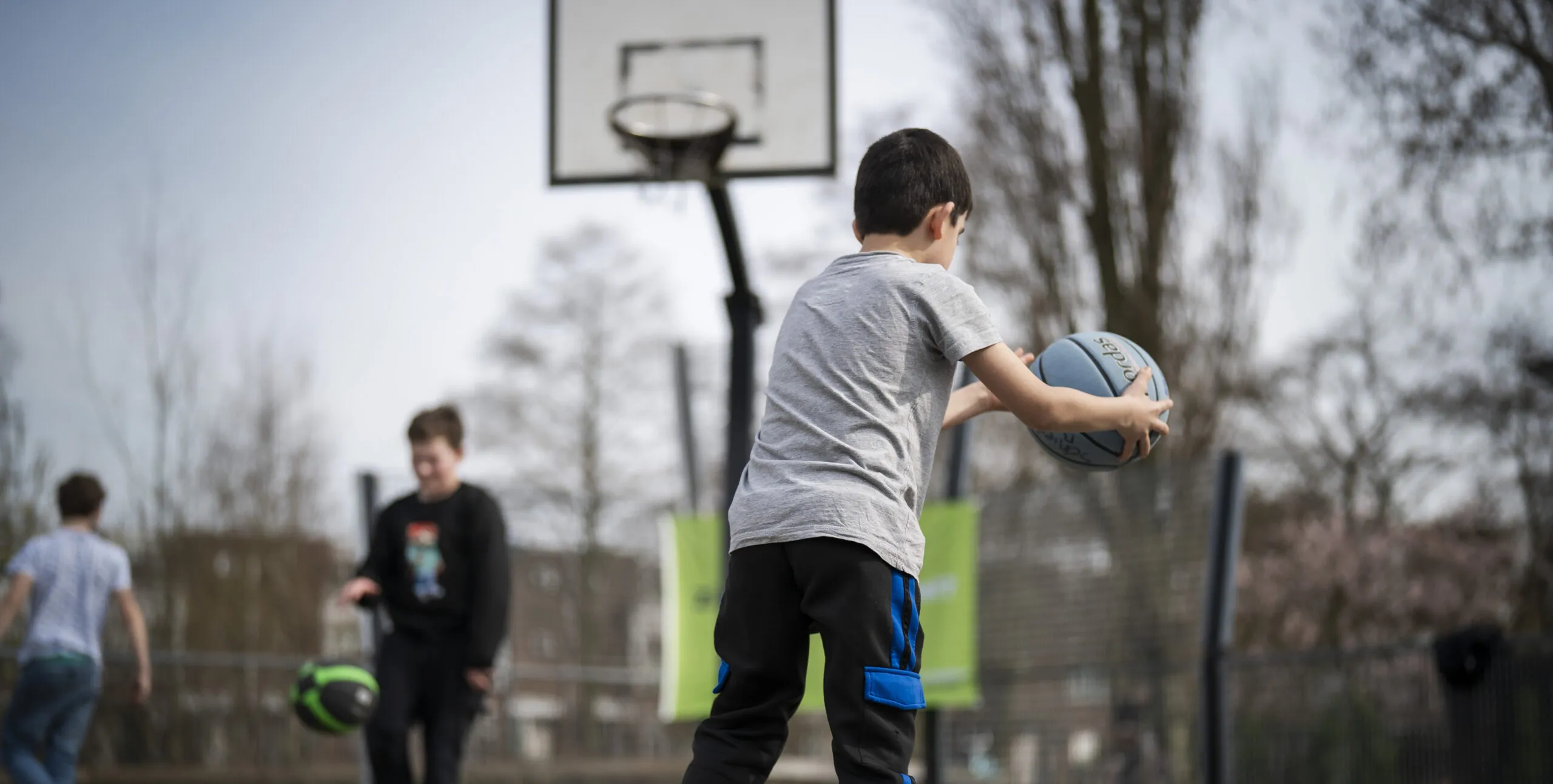 Kinderen die meedoen met een activiteit op een sportpleintje
